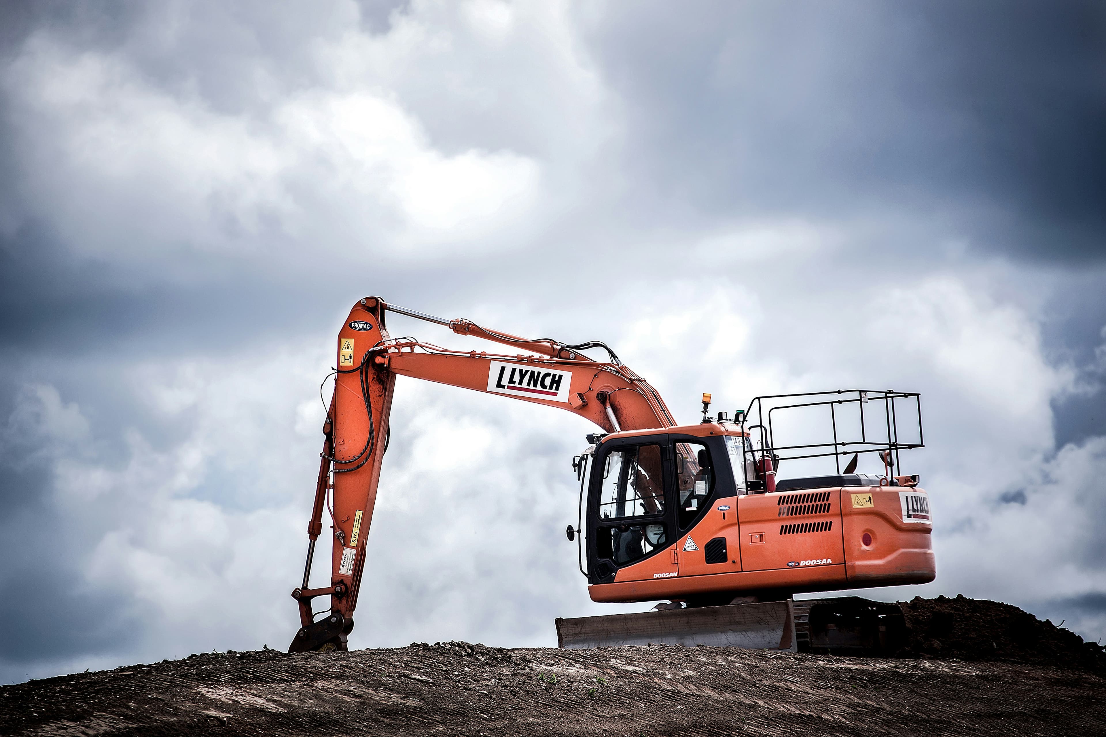 Excavator under dramatic sky used as feature section backdrop