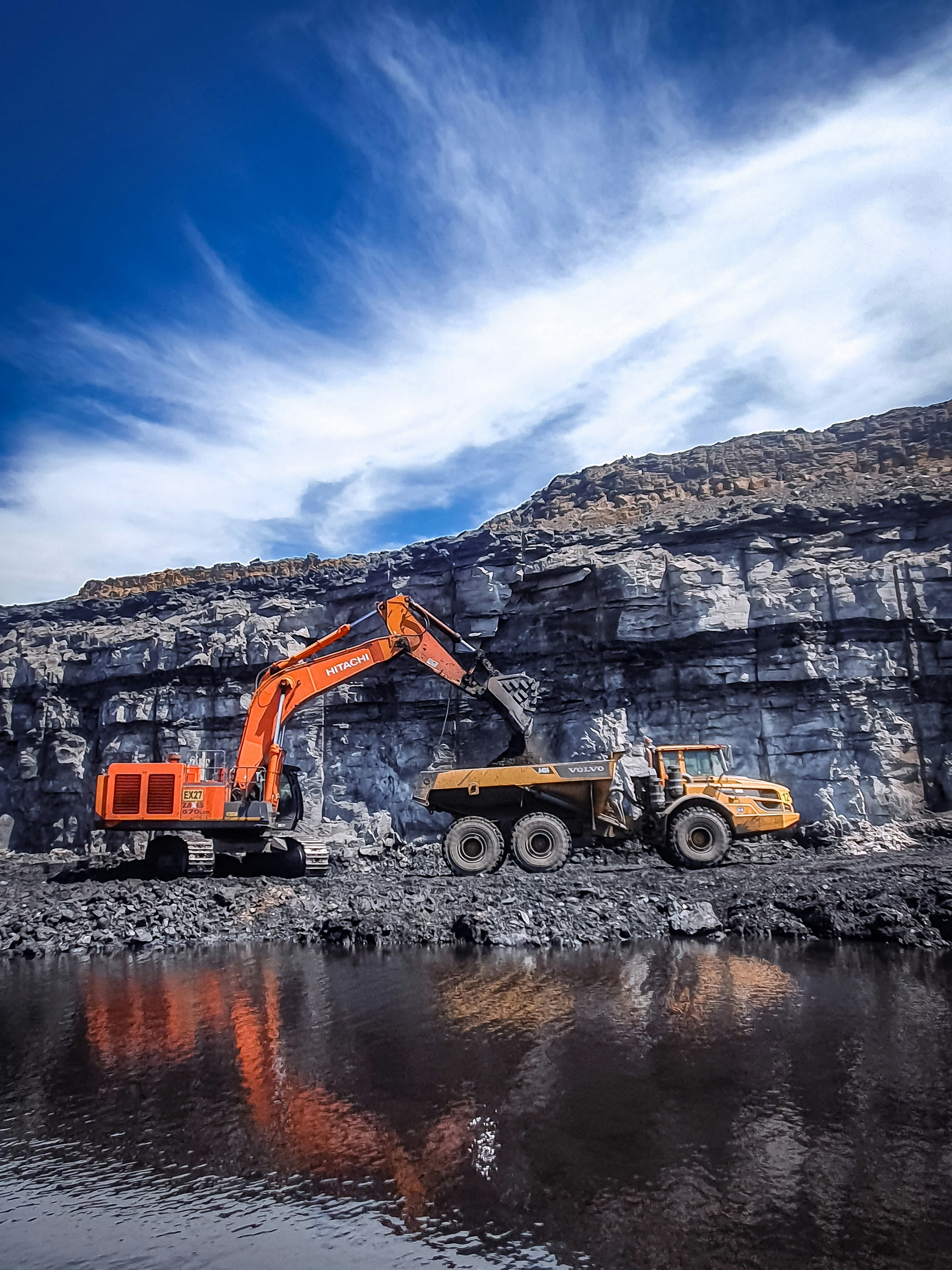 Dramatic aerial mining landscape behind comparison table